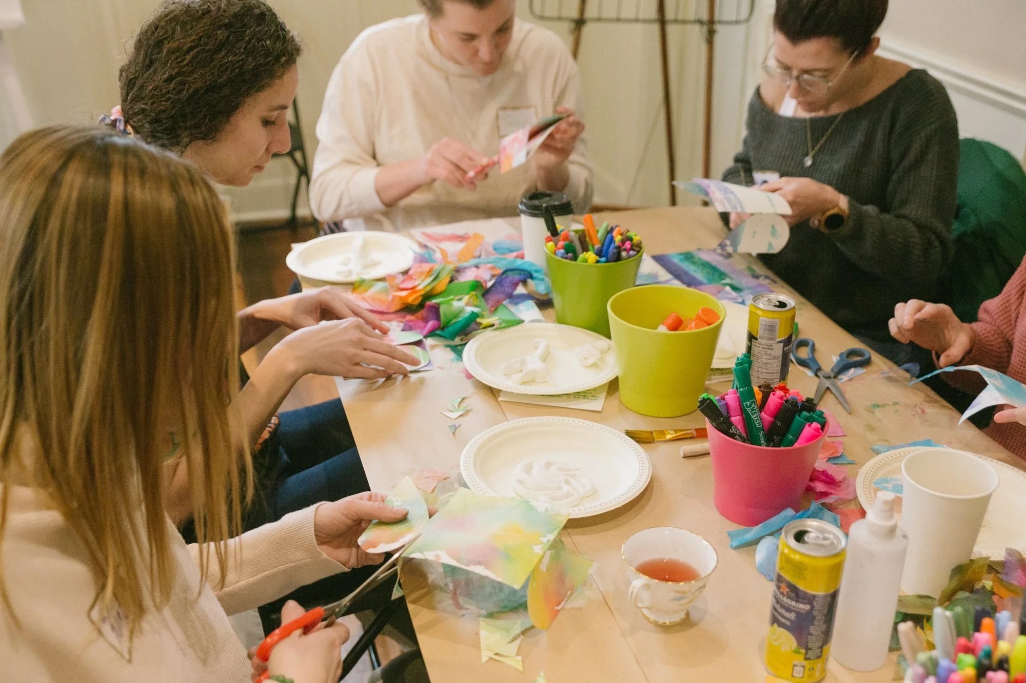 People gather around a table to make art. Courtesy of Canopy Art & Wellness